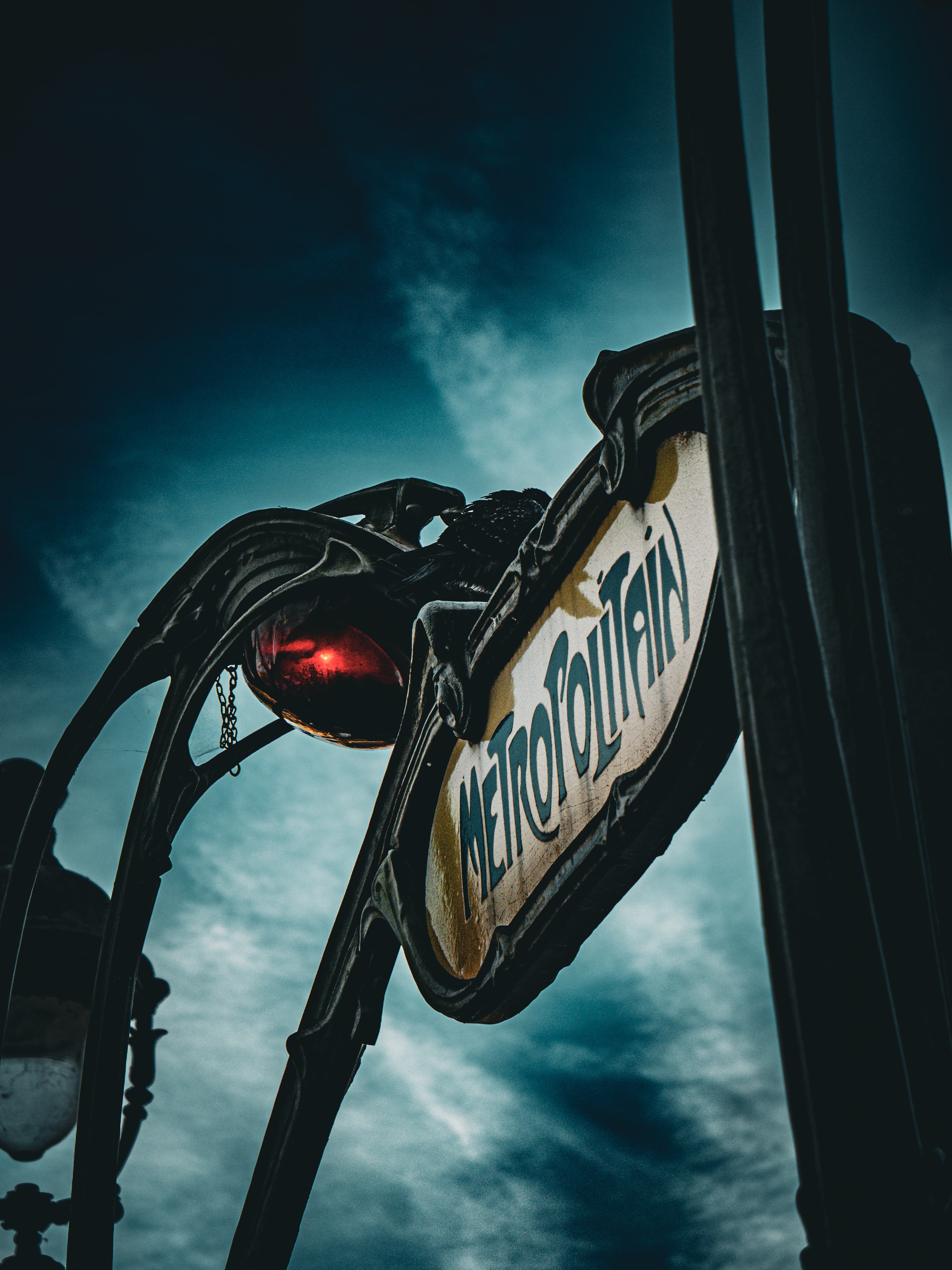 Portrait fine art photograph of a classic Paris Métropolitain sign against a dramatic sky
